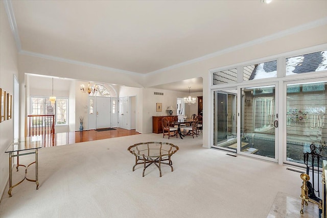 living room with ornamental molding, carpet flooring, and an inviting chandelier