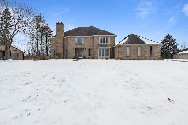 view of snow covered back of property