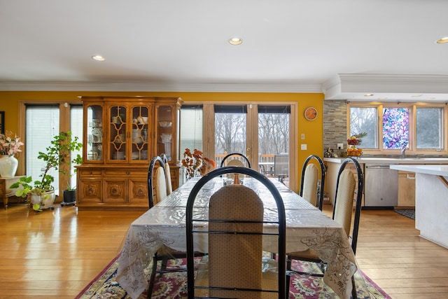 dining area with crown molding and light hardwood / wood-style flooring