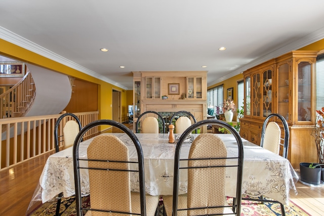 dining area with hardwood / wood-style floors and crown molding