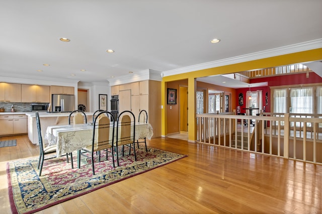 dining space featuring ornamental molding and light wood-type flooring