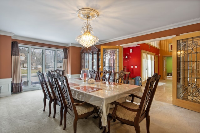 carpeted dining area with crown molding and a chandelier