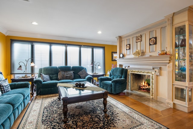 living room featuring hardwood / wood-style flooring, a high end fireplace, and ornamental molding