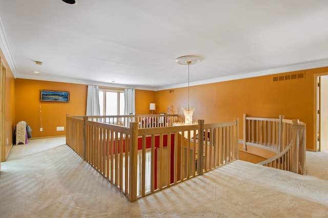 corridor featuring crown molding, light carpet, and a notable chandelier