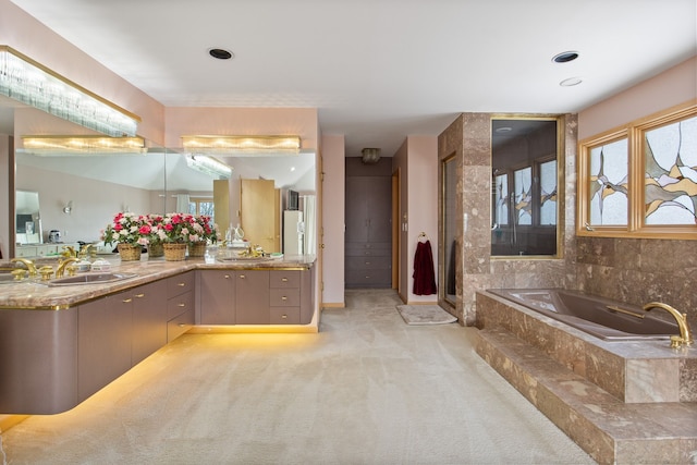 bathroom with vanity and a relaxing tiled tub