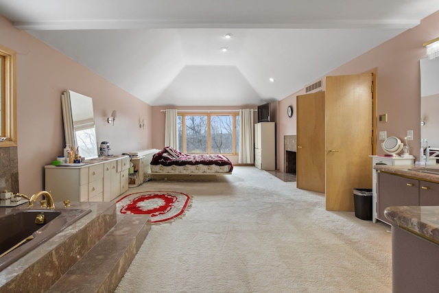 bedroom with sink, vaulted ceiling, and light carpet