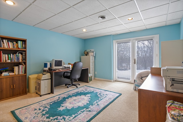 office space featuring a paneled ceiling and light carpet