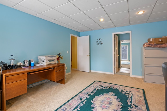 carpeted home office with a paneled ceiling