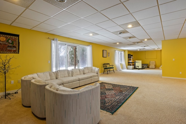 living room featuring carpet and a paneled ceiling