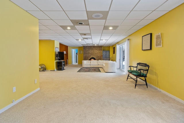 sitting room featuring light carpet, a fireplace, and a paneled ceiling