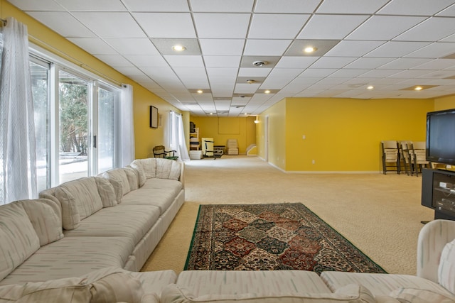 carpeted living room with a paneled ceiling