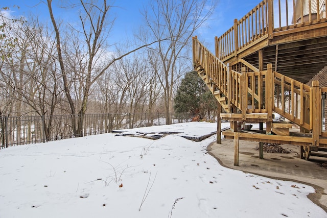 yard covered in snow featuring a deck