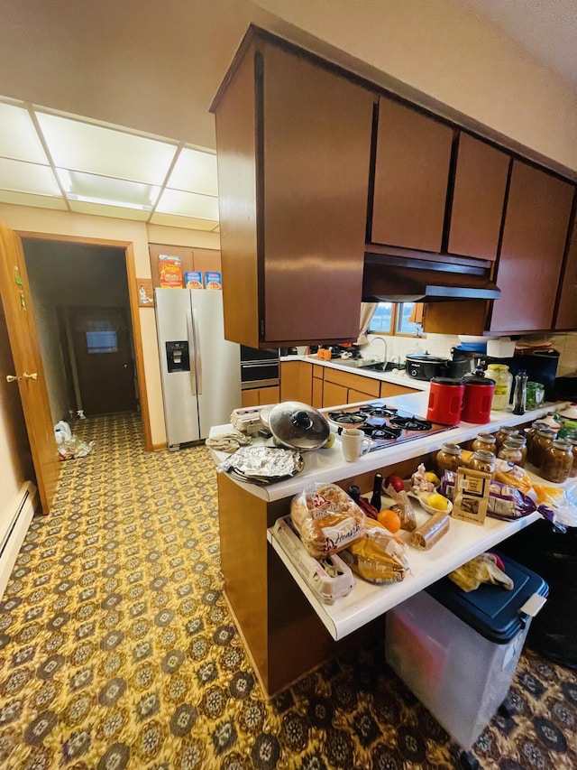 kitchen featuring stainless steel fridge with ice dispenser, a baseboard radiator, and white gas stovetop