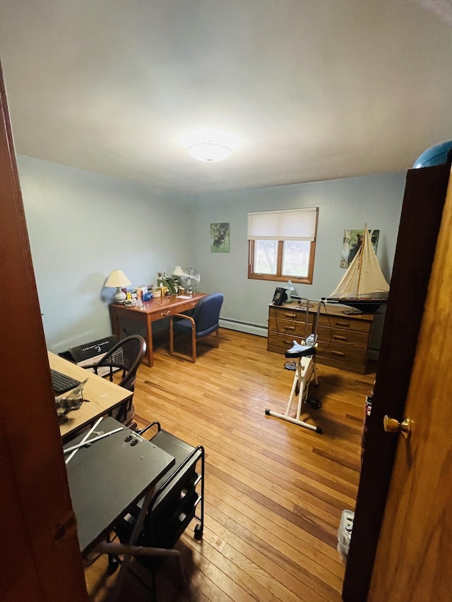 office space featuring baseboard heating and light hardwood / wood-style floors