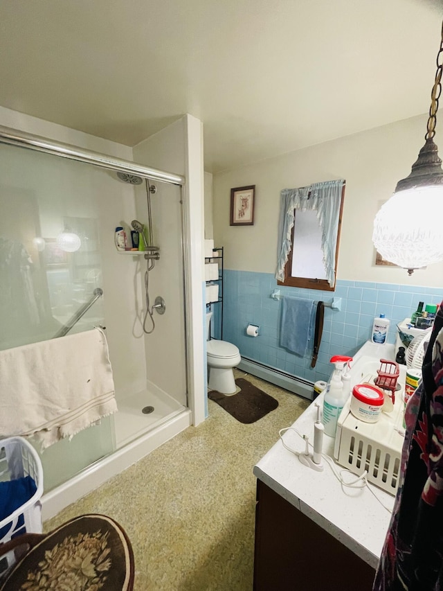 bathroom featuring tile walls, vanity, a baseboard heating unit, an enclosed shower, and toilet