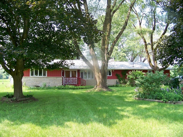 exterior space featuring stone siding and a front lawn