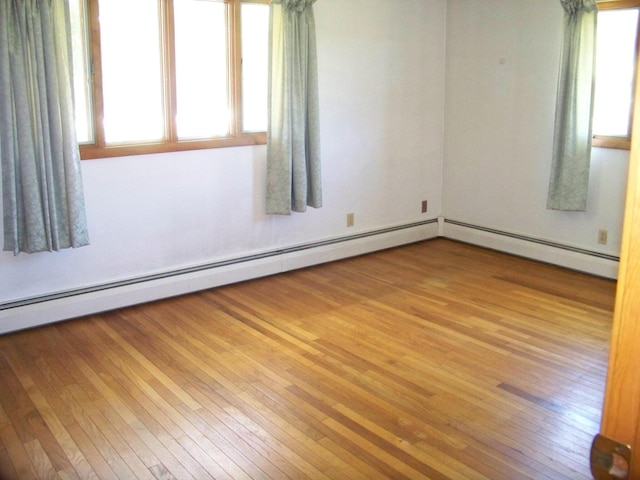 unfurnished room featuring a baseboard radiator and wood finished floors