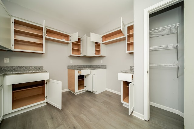 kitchen with wood-type flooring and light stone countertops