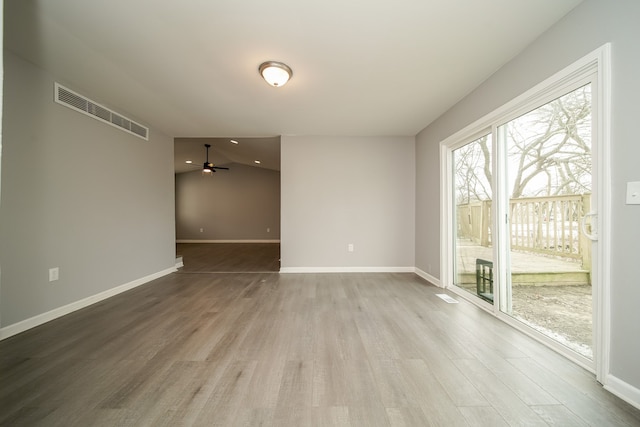 empty room featuring vaulted ceiling, hardwood / wood-style floors, and ceiling fan