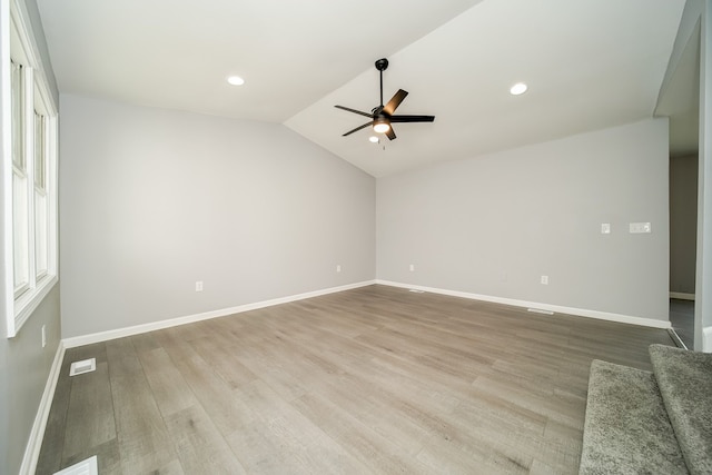 empty room with light hardwood / wood-style flooring, vaulted ceiling, and ceiling fan