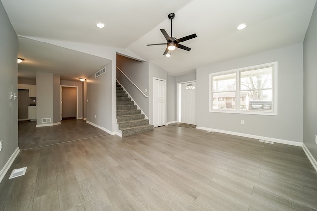 unfurnished living room with lofted ceiling, hardwood / wood-style flooring, and ceiling fan