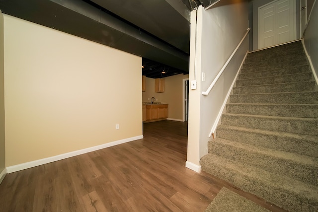 stairs featuring hardwood / wood-style floors and indoor wet bar