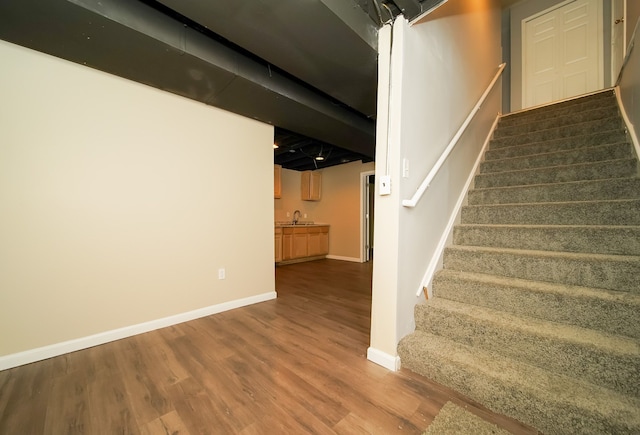 stairway featuring hardwood / wood-style flooring and sink