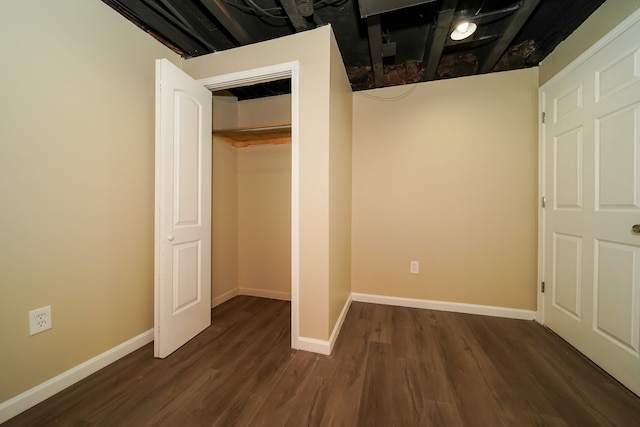 unfurnished bedroom with dark wood-type flooring and a closet