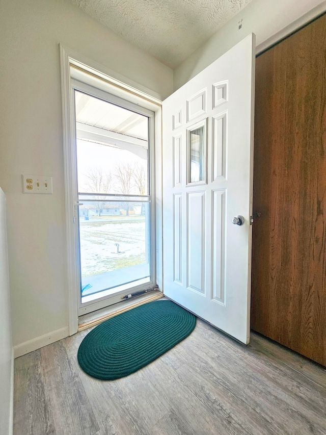 doorway featuring a textured ceiling and light wood-type flooring