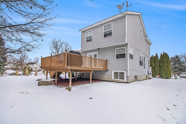 snow covered house featuring a deck