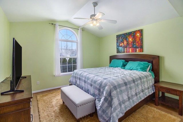 bedroom featuring hardwood / wood-style floors, vaulted ceiling, and ceiling fan