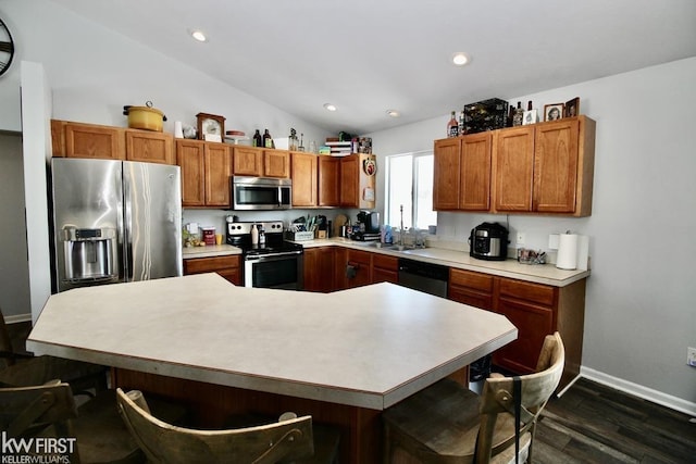 kitchen featuring dark hardwood / wood-style flooring, sink, vaulted ceiling, and stainless steel appliances