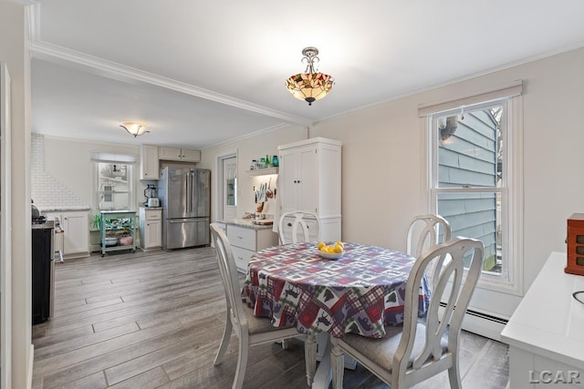 dining space with ornamental molding and hardwood / wood-style floors