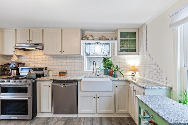 kitchen featuring sink, light hardwood / wood-style flooring, appliances with stainless steel finishes, backsplash, and light stone counters