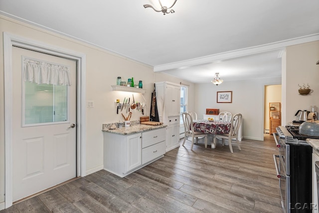 kitchen featuring range with two ovens, light stone counters, white cabinets, and light hardwood / wood-style floors