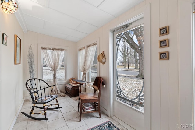 sitting room with lofted ceiling, light tile patterned floors, and plenty of natural light