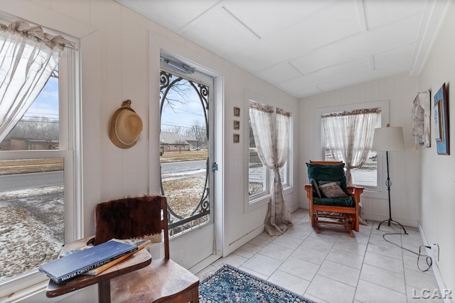 doorway with lofted ceiling, a wealth of natural light, and light tile patterned floors