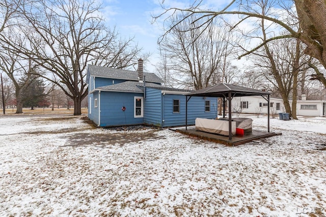 snow covered rear of property featuring a gazebo