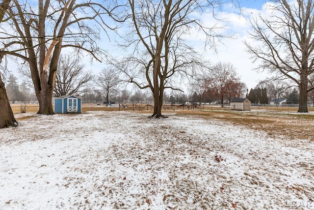 yard covered in snow featuring a storage shed