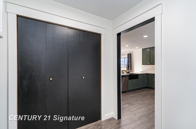 hall featuring recessed lighting, a sink, and wood finished floors