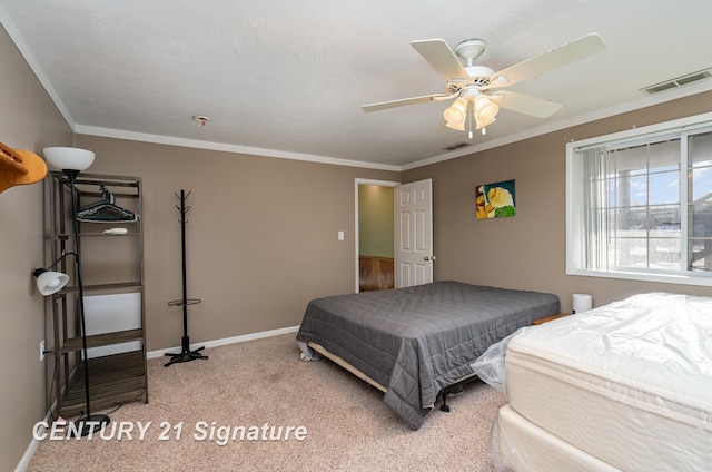 carpeted bedroom featuring visible vents, crown molding, baseboards, and ceiling fan