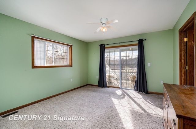 interior space featuring a ceiling fan, carpet, visible vents, and baseboards