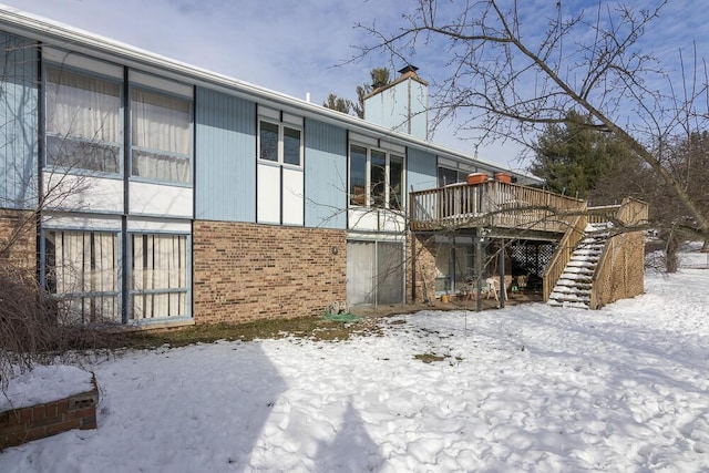 view of snow covered exterior featuring a wooden deck