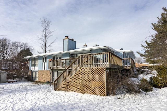 snow covered house featuring a deck