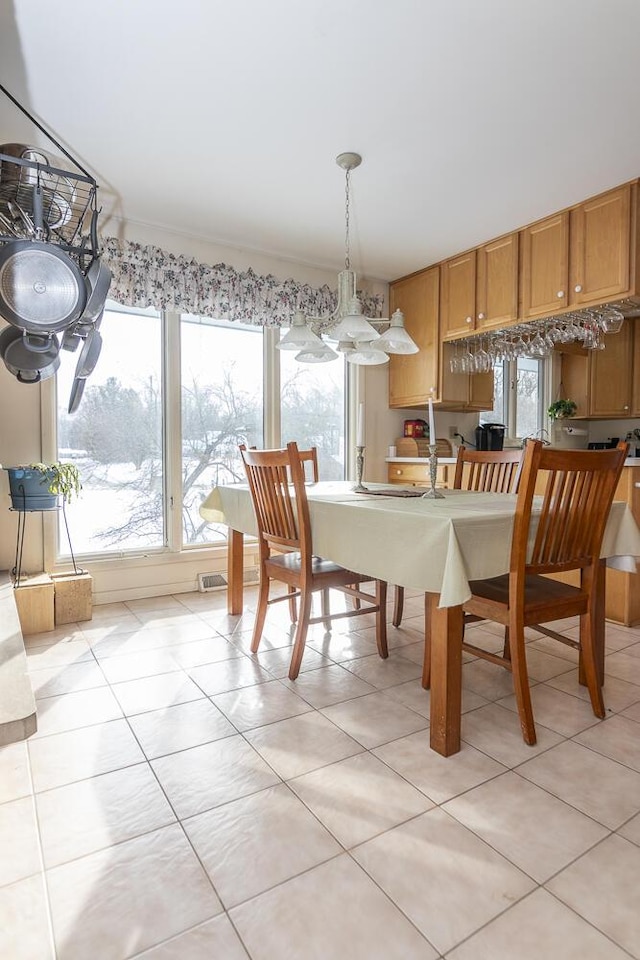 dining space featuring crown molding and light tile patterned floors