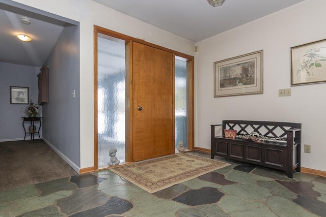 entrance foyer featuring dark carpet