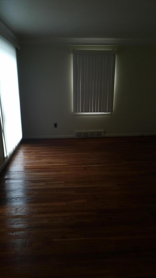 empty room with dark hardwood / wood-style flooring