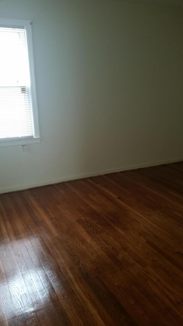 unfurnished room featuring dark wood-type flooring