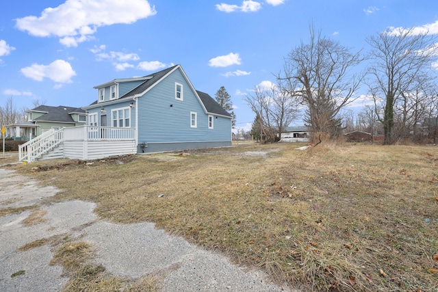 view of side of home with a wooden deck and a lawn