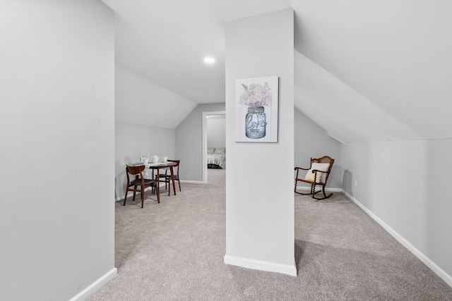 additional living space featuring vaulted ceiling and light carpet